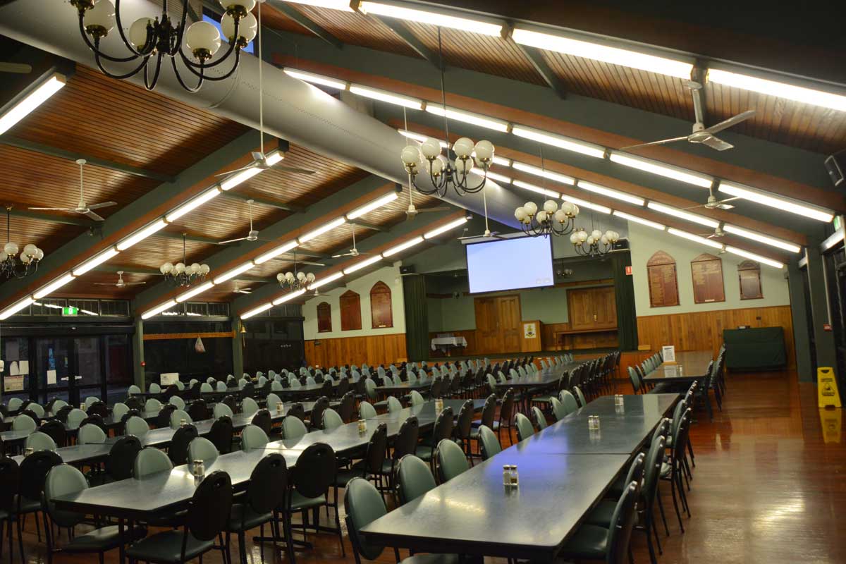 Central Queensland University – Motorised screen with projector on stage in dining hall.